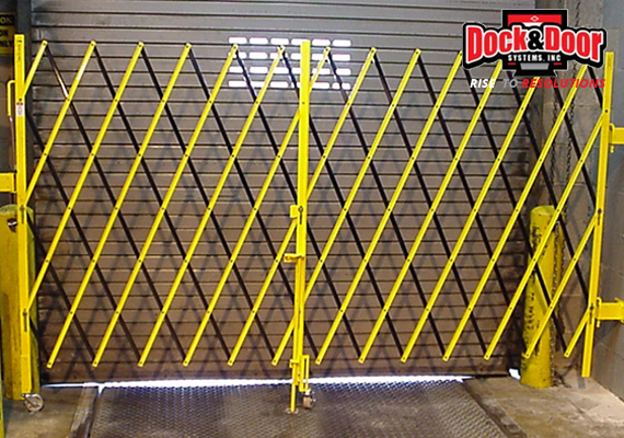 Yellow expandable folding security gate across a loading dock opening