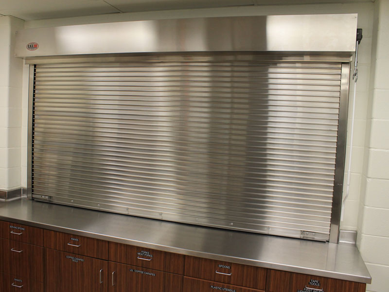 Stainless steel rolling counter shutter over a serving counter