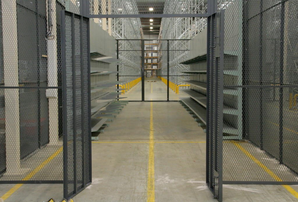 Wire mesh security cage enclosing a warehouse storage aisle