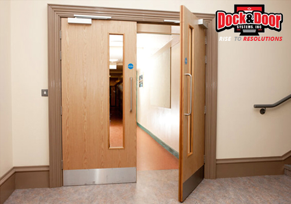 Wood-veneer fire-rated doors with vision panels in an interior hallway