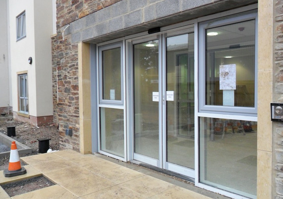 Automatic sliding glass entrance door at a building entrance under construction