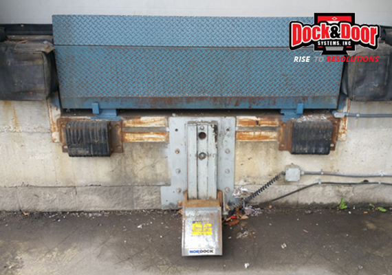 Hydraulic dock leveler with pump unit at a loading dock