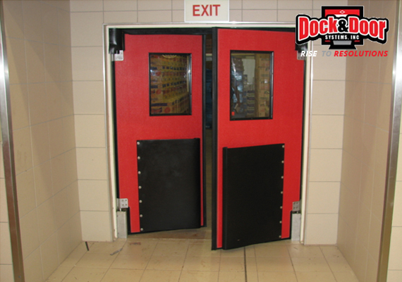Red double swinging traffic doors with impact-resistant kick plates