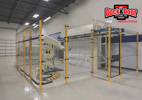 Wire mesh security cage enclosing an industrial robotic arm