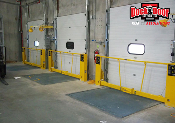 Yellow safety gates installed across loading dock door openings