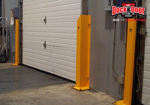 Yellow steel guard posts flanking a loading dock door opening