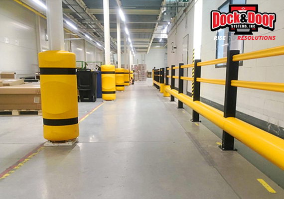 Yellow column protectors and guardrail barriers lining a warehouse aisle