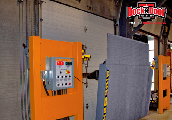 Specialty dock leveler with an integrated control panel at a warehouse loading door